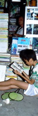 A Vietnamese boy reading in a book shop 
